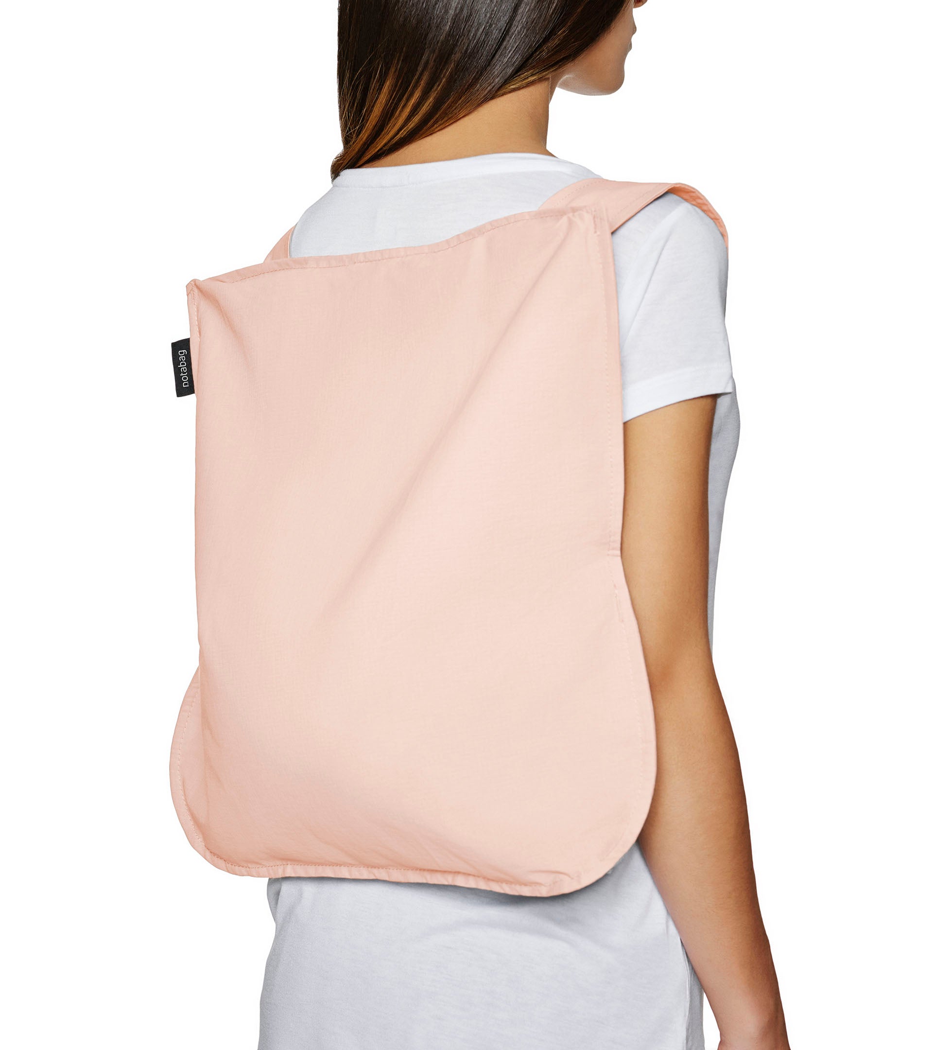 Notabag Foldable reusable backpack/tote in rose unfolded to backpack and on a models back