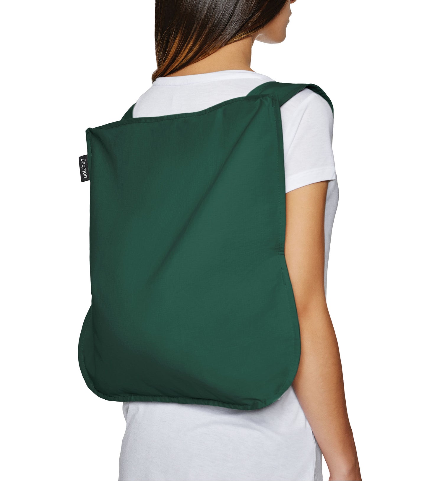 Notabag Foldable reusable backpack/tote bag in forest green unfolded to backpack and on a models back